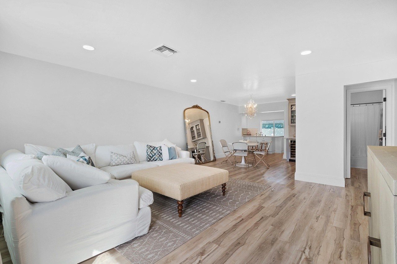 Bright living room with a pale sectional sofa and dining area