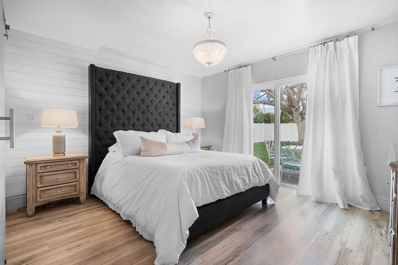 Main bedroom with a dark upholstered bed and white linens