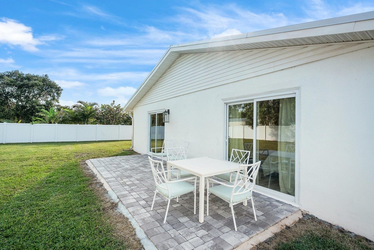Outdoor patio with a dining table beside the backyard